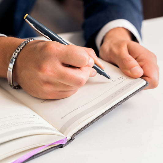 Close up of someone writing with a pen on paper.