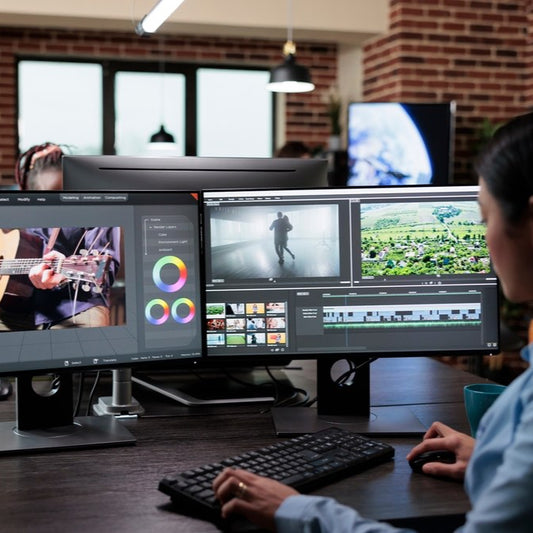 Girl editing videos on monitor.